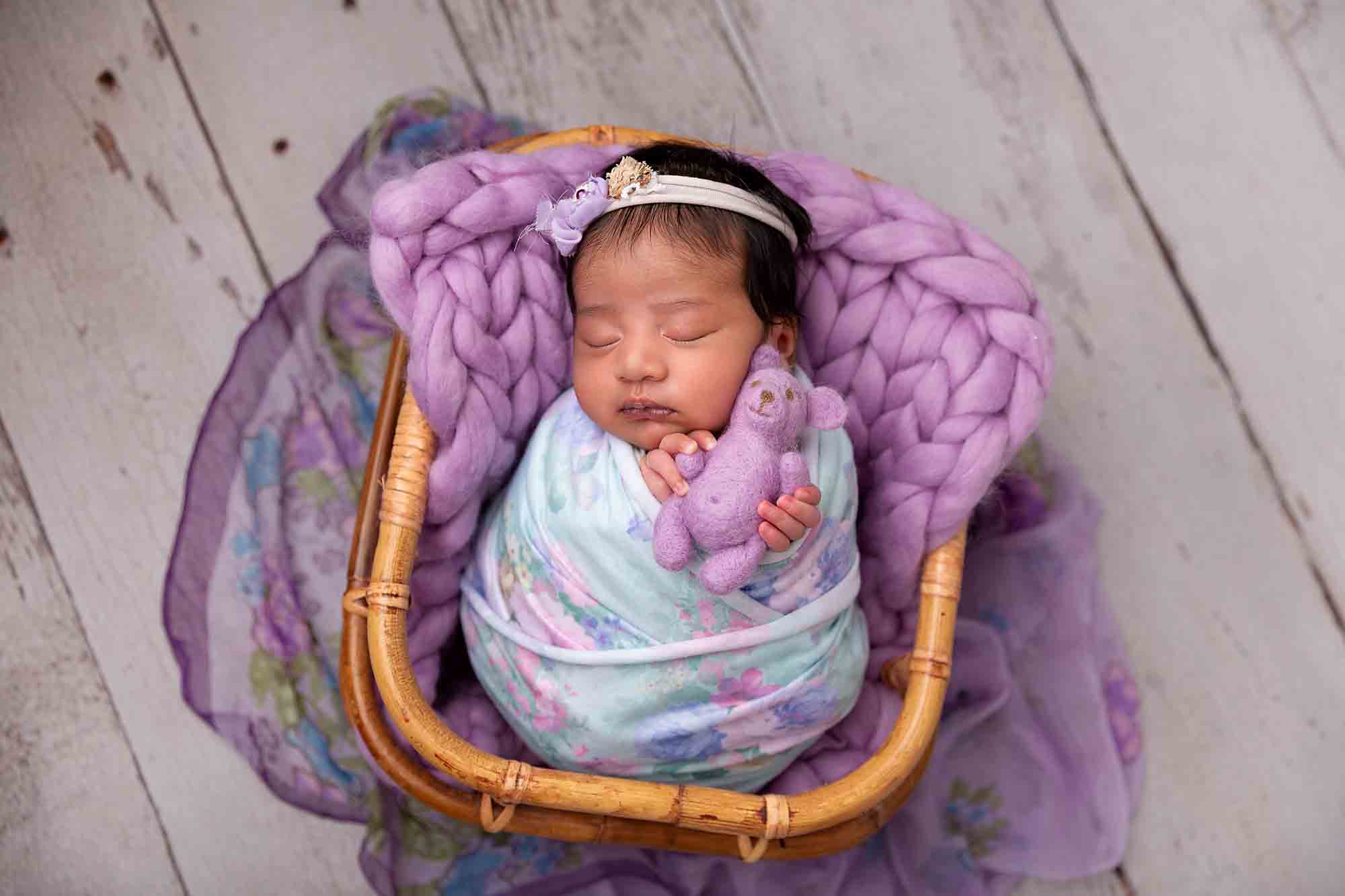newborn holding teddy