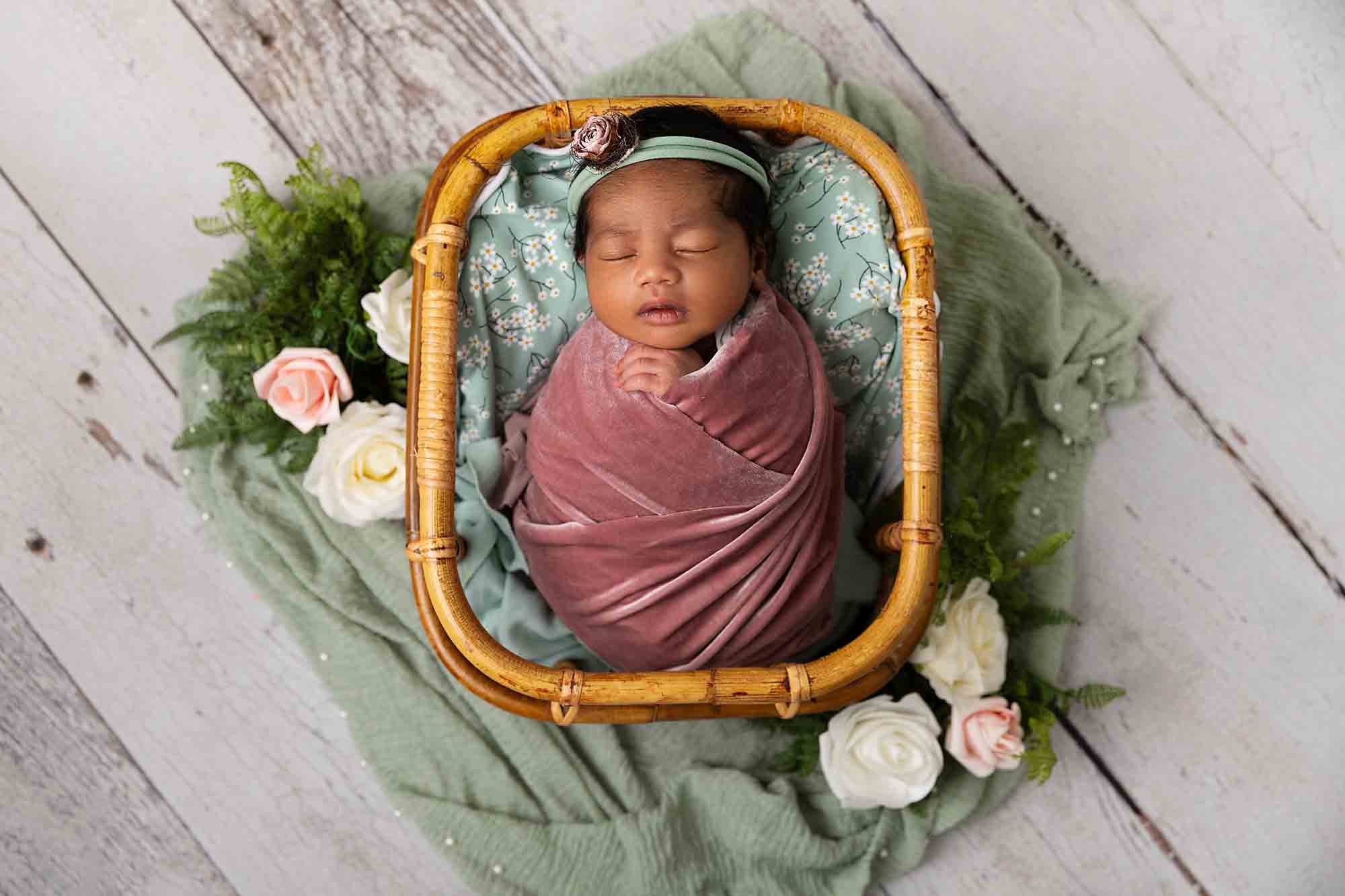 pink and green basket with baby