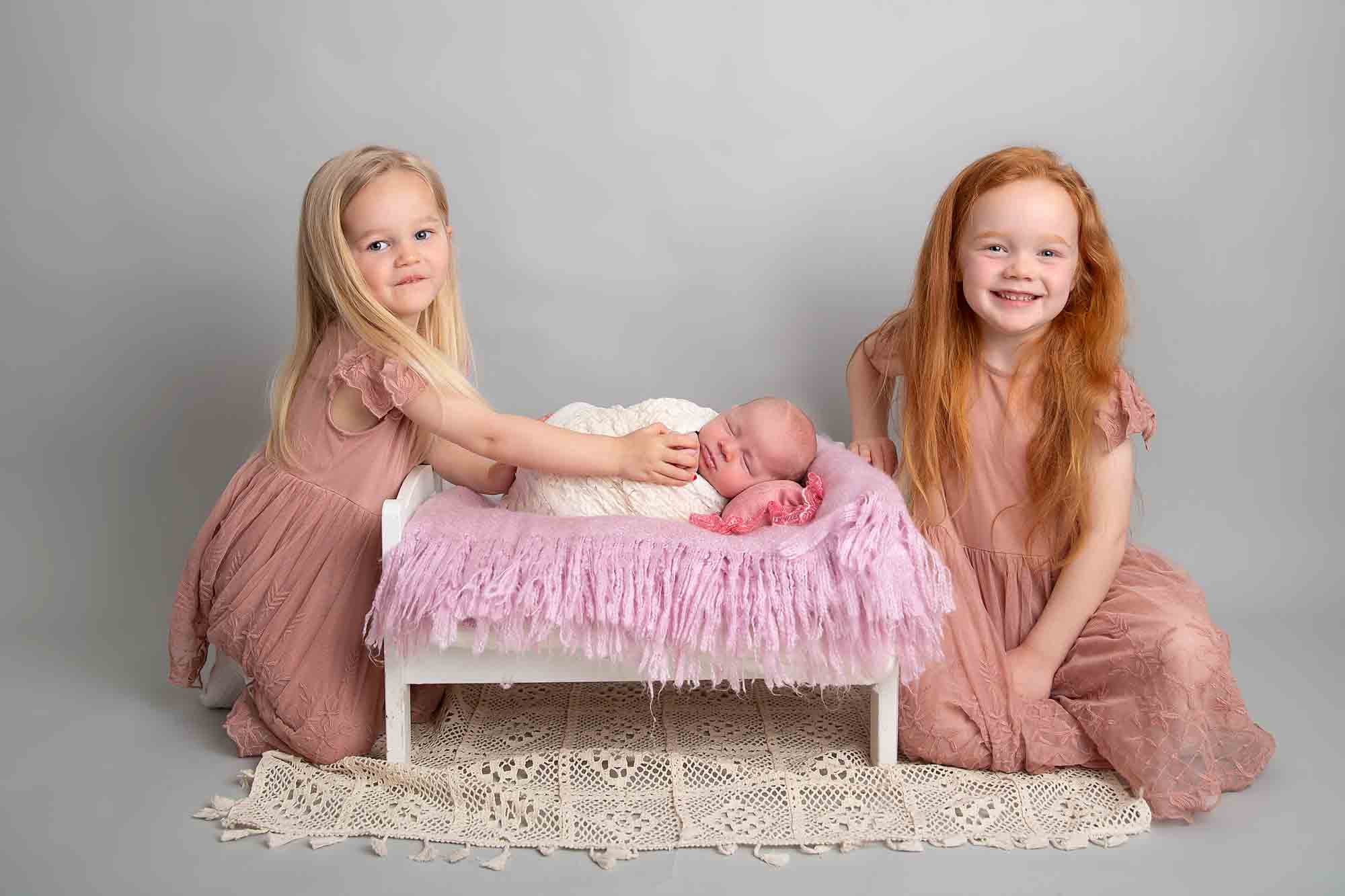sibling girls with newborn sister