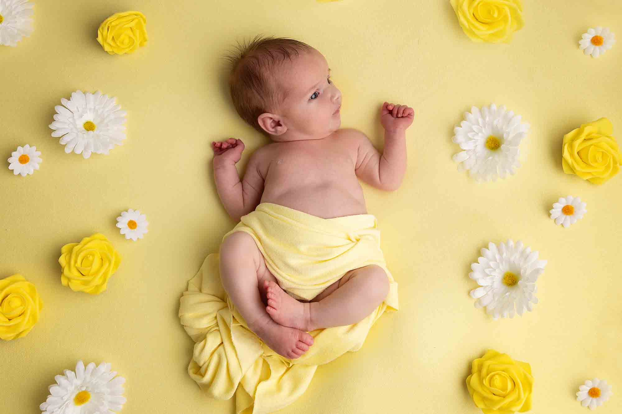 baby surrounded by daisies